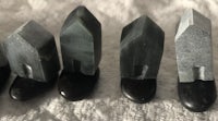 a row of black and gray stones on a white surface