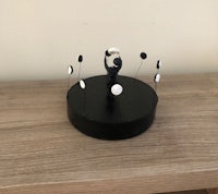 a black and white figurine on top of a wooden table