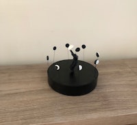a black figurine on top of a wooden table