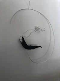 a black and white sculpture hanging on a wall
