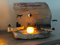 a piece of wood with a candle on it